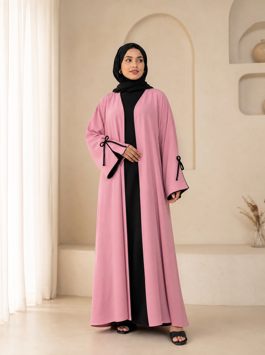 Soft pink open-front abaya cardigan with black bow-tie cuffs